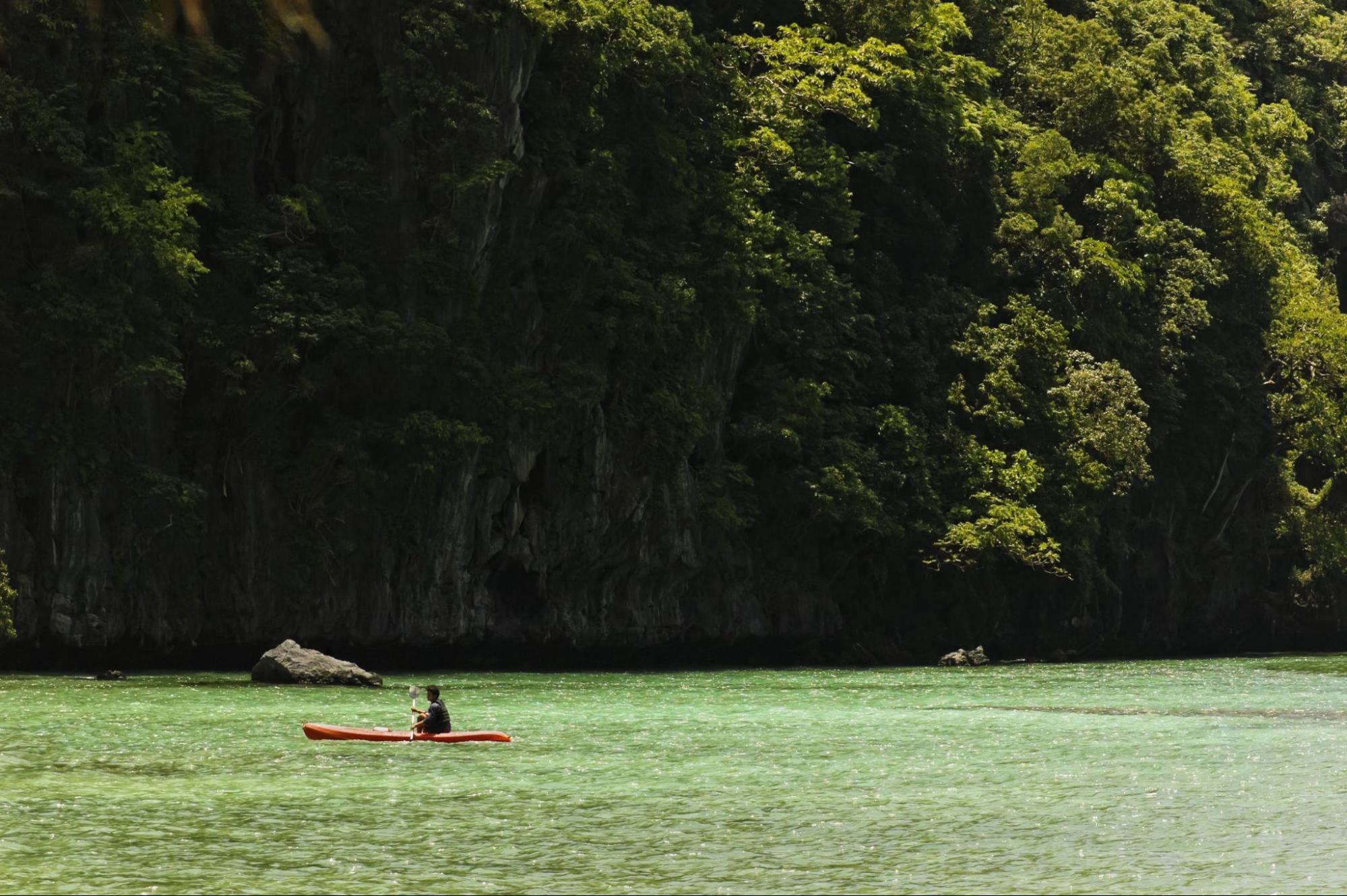 Young man kayaking in the big lagoon of El Nido, Palawan, Philippines Young man kayaking in the big lagoon of El Nido, Palawan, Philippines
